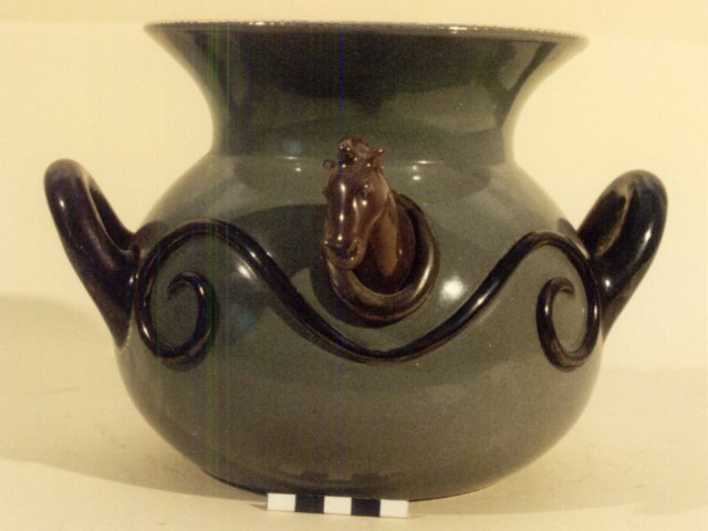 Vaso  - Vaso trozzelliforme con due anse alternate a due teste equine. Opera di Antonio Linoci. Lato A.Scarica il file