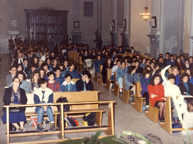 Cerimonia di inaugurazione as 1988/89 - Nella chiesa Madre si tiene la cerimonia religiosa per l’inaugurazione dell’anno scolastico 1988/89. In prima fila, a sinistra, la collaboratrice Dorotea Quaranta. Dietro di lei si riconoscono il Preside Antonio Arces ed il prof. Cosimo Fornaro.Scarica il file