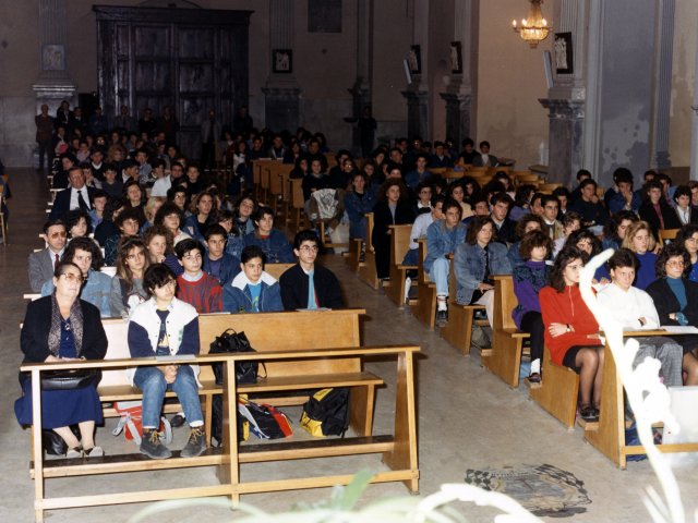 Cerimonia di inaugurazione as 1988/89 - Nella chiesa Madre si tiene la cerimonia religiosa per l’inaugurazione dell’anno scolastico 1988/89. In prima fila, a sinistra, la collaboratrice Dorotea Quaranta. Dietro di lei si riconoscono il Preside Antonio Arces ed il prof. Cosimo Fornaro. Scarica il file