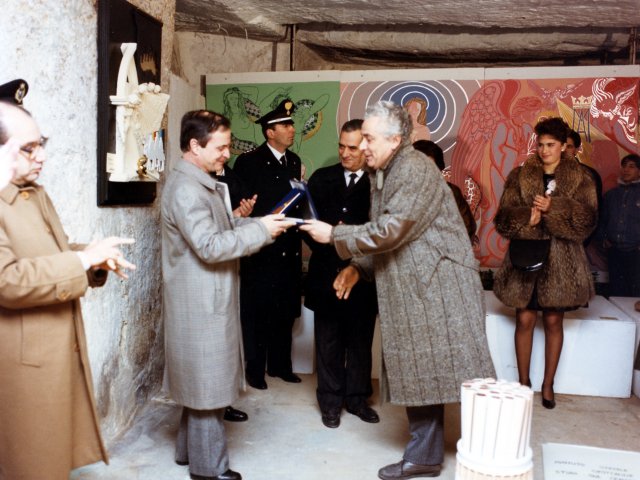 9ª Mostra del Presepe - 17/12/88 - 8/1/89 - Nel Trappeto Pinca si svolge la 9ª Mostra del Presepe 88/89, allestita dall’Istituto Statale d’Arte. Il Preside De Filippis dona al Sindaco di Grottaglie dott. Rocco Maggi una targa realizzata dalla sezione Metalli. Scarica il file