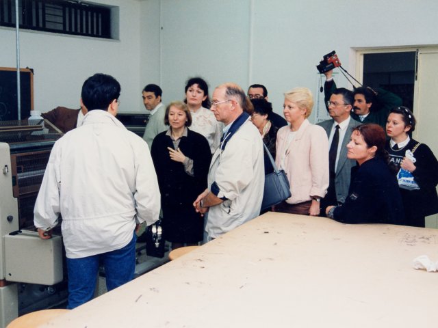 Visita della delegazione della città di Brest - Una delegazione del comune francese di Brest (Bretagna), città gemellata con Taranto, torna, per la seconda volta a visitare la nostra scuola. La delegazione visita il laboratorio di tipografia della sezione Arti Grafiche. Di spalle, vicino alla macchina Scarica il file